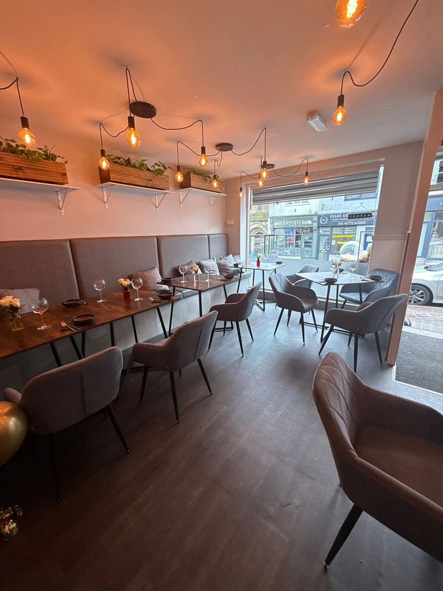 Inside Elvin's Kirkham, warm pendant lights and banquette seating in the dining room